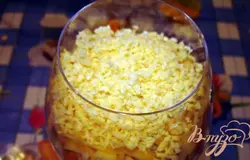 Натрите на крупную терку твердый сыр. При покупке сыра берите сыр с ярким вкусом. Сыр не должен быть пресный. Лучше соленых сортов. Смазать майонезом. Завершающим слоем натрите на мелкую терку желток. Украсьте верхний слой салата. Желток натертый таким образом имеет привлекательный и праздничный вид, воздушный.