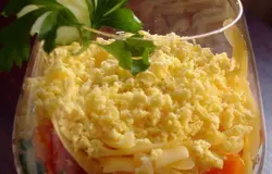 Готово! Теперь бокал с салатом нужно украсить. Для этого используйте продукты, входящие в состав салата. Это могут быть : кусочек яйца, морковки, огурец или какая-то имеющаяся зелень. Можно использовать дольку лимона. Такой салат можно подать к столу почти сразу, но лучше дать ему пропитаться. Салат вкусный именно в холодном виде. Салат легкий, рыбный (мы не так часто используем в своем рационе рыбные блюда и салаты), вкусный и празднично оформлен. Для подачи салата я использую большой коньячный бокал. Выглядит шикарно, но кушать не совсем удобно. Выбирайте более широкий бокал в форме буквы V. Можно заже взять стакан. Цель одна- горлышко бокала должно быть максимально широким.