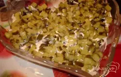  У огурцов удалить «попки» порезать мелким кубиком. Выложить в салатник, смазать майонезом.