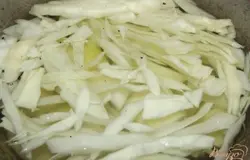Готовый бульон процедите несколько раз. Корень петрушки больше не нужен и его можно выкинуть. Кастрюльку под суп вымойте и снова влейте в нее бульон. Доведите бульон до кипения и положите в него капусту и куриное мясо.