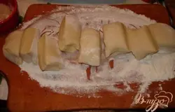 Духовку разогреть до 180 градусов. Продукты для теста хорошо смешать. Сформировать из теста шар, из шара колбаску. Нарезать колбаску на 5-6 частей.