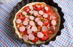 Сосиски нарезаем кружочками и выкладываем следующим слоем.