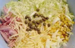 Яйца порубите, можно кубиками, можно полосками. Или пропустите через крупный пресс. Колбасу или ветчину порежьте полосочками. Сыр натрите на крупной терке. Капусту порежьте, я выбрала среднюю толщину. Соединяем все ингредиенты. Добавляем каперсы (можно их меленько порезать, если хотите), кукурузу. Солить по желанию, я не солила совсем, практически в каждом продукте есть соль, да и майонез сделала солонковатый.