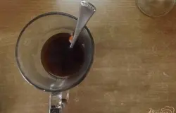 В стакан с медом и корицей через ситечко вливаем кофе до половины.