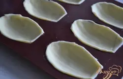 Формочки для печенья "Мадлен" смазать маслом и выложить тесто. Хорошо прижать по краям и срезать лишнее.