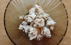 Когда курица готова, ее нужно порвать на кусочки и выложить слоем на дне тарелочки, в которой будете подавать салатик.