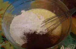 Добавьте муку, какао и соду гашенную. Смешайте ложкой.