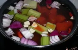 В большом количестве воды отварить фасоль с очищенной и произвольно нарезанной морковью, луком, сельдереем, томатами и чесноком.