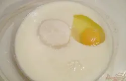 В глубокой мисочке смешиваем теплый кефир с сахаром и куриным яйцом. Перемешиваем. Нужно растворить сахар полностью.