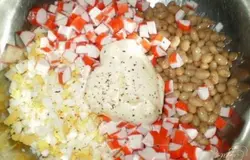 Яйца пропустить через крупный пресс, или порезать кубиком. Крабовые палочки порезать размером с фасолину. Соединяем ингредиенты: яйца, фасоль, крабовые палочки, майонез, перец, соль.