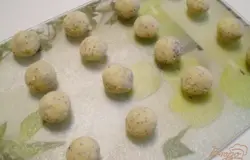 Спустя час вынимаем тесто для печенья из морозилки и с помощью чайной ложки набираем тесто и руками катаем шарики. Включаем духовку на максимальную мощность, прогреваем. Выкладываем шарики на противень, застеленный бумагой для выпекания или силиконовым ковриком. Можно использовать фольгу. Духовку выставляем на 170 градусов. Ставим противень на 15 минут в духовку. Выпекаем до румяного цвета.