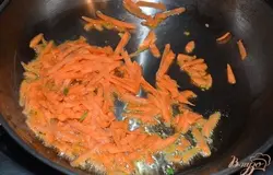 Морковь очистить от шкурки. Натереть на крупную терку. На сковороде разогреть растительное масло и обжарить морковь, периодически помешивая, до мягкого состояния. Морковь изменит цвет.