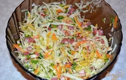 Обжаренную морковь добавьте в салатник к остальным продуктам. Твердый сыр натрите на крупную терку и тоже добавьте в салатник. Перемешайте все. Заправьте салат сметаной. Соль и перец по вкусу. Салат лучше подавать холодным. Для этого при приготовлении салата нужно использовать продукты охлажденные или поставить заправленный салат в холодильник на 20 минут для охлаждения.