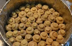 Для начала подготовим продукты для салата. Куриное филе отварим в подсоленной воде с добавлением лаврового листа и перца горошком. Овощи – картофель, морковь и яйца отварим до готовности. Все остужаем, начинаем выкладывать салат. Для этого я использовала форму для выпечки тортов, можно использовать любую, поменьше, например. Застилаем дно и бока формы пленкой пищевой. Это делается для того, чтобы в дальнейшем салат хорошо перевернулся. Выкладываем первым слоем, по всему периметру шампиньоны шляпками вниз.