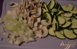 Нарезать цукини, репчатый лук и грибы.
