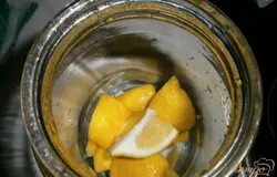 Лимон вымыть и разрезать на 8 частей, убрать косточки. Кусочки лимона положить в банку.