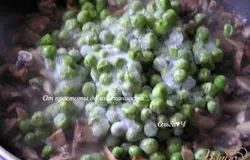 Из сковороды слить масло, влить вино и готовить, пока оно не выпарится вдвое. Добавить нарезанные грибы и горошек, готовить, пока не выпарится вся жидкость.