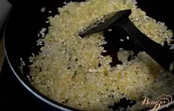 Разогреть сковороду затем выложить сливочное масло и оливковое масло. Порезанный лук выкладываем,когда разойдется масло и жарим до мягкости. Добавим рис и все перемешаем.
