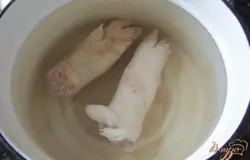 Свиные ножки промыть, положить в подходящею посуду, залить водой. Поставить на плиту. Варим 30 минут.