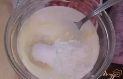 Вначале сделаем заливку из сметаны, которой мы будем заполнять мучную основу. Для этого в тарелочке смешиваем сметану (чем жирнее, тем гуще и сытнее) с сахаром, сахаром ванильным, растопленным сливочным маслом и одной столовой ложкой пшеничной муки. Хорошенько перемешиваем, чтобы комочки муки растворились, а масса стала полностью однородной.