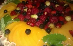 Многие любят торты с ягодами, поэтому я также остановила на них свой выбор. Кроме того, внешние края торта также нужно декорировать – мне понадобились магазинные вафельные трубочки с начинкой, которые украшены темной полоской. Выставляла их вертикально по всей окружности торта (они довольно хорошо прилипают в суфле), а для пущей уверенности, что не отпадут (а также в эстетических целях), перевязала лентой. Консервированные персики обсушила, надрезала и уложила по внешнему кругу. Малина, черника и земляника – по всему торту. Для закрепления – желе из 150 мл воды, 1 чайной ложки желатина и 1 чайной ложки сахара. Дополнительный элемент и ароматическая составляющая - свежая зелень мелиссы.