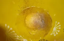 Готовим тесто для кляра. В глубокую миску разбиваем куриное яйцо, добавляем соль и черный молотый перец.