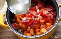 Помидоры нарезать кубиками, морковь кружочками толщиной по 0,5-0,7 см, чеснок - пополам. Добавить к мясу. Посолить, поперчить и залить мясным бульоном. Тушить на медленной огне до готовности мяса, около 2 часов.