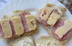Сыр нарезать. Выложить поверх колбасы.