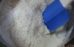 Когда сахар полностью растворится, высыпать туда же кокосовую стружку и очень хорошо перемешать лопаточкой, взбивать больше не нужно.