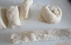 Тесто разедлить на равные кусочки.Каждый кусочек скатать в небольшой жгут и завязать узелок.