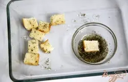 Обмокнуть кусочек хлеба в ароматизированное масло 1й стороной, выкладывать кусочки в форму для запекания маслом вверх.