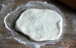 Перевернуть лепёшку швом вниз и ещё раз раскатать.