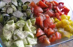 Нарезать примерно одинаковыми кусочками кабачок, цуккини, помидоры и сладкий перец, посыпать прованскими травами, посолить, поперчить.