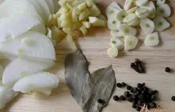 Лук нарезать полукольцами, чеснок - дольками, имбирь примерно такими же кусочками. Перец горошком слегка раздавить. Подготовить лавровые листы и гвоздику.