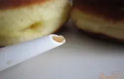 Для наполнителя можно взять любой конфитюр по вкусу. Только его нужно сначала взбить блендером до гладкой текстуры , т.е. сделать его без комочков. Иначе начинка не будет проходить в тонкий носик насадки .Начинить все пончики.