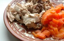 Остывшее мясо и морковь мелко нарезать. Кости и лук - удалить. Положить мясо с морковью в суп. Варить все вместе еще 10 минут.
