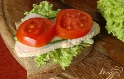 Собрать бутерброд, выложив на ломтик хлеба лист салата, затем мясо, тонко нарезанные кусочки огурцов и помидоров.