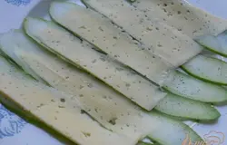 Также нарезать сыр и выложить на пластины огурцов. Поперчить.