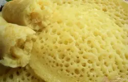Готовый блинчик (пористую сторону) щедро смазываем сверху растопленным маслом, смешанным с медом.