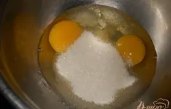 Яйца смешать с солью, ванильным сахаром и 1 ст. л. сахара.