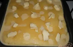 Залить смесью пирог, обильно посыпать сахаром (5 столовых ложек). Разложить по поверхности пирога кусочки сливочного масла.