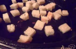 Булку нарезаить кубиками. В сковороде разогреть растительное масло и поджарить крутоны.В миске довести до кипения посоленную воду. Разбить яйцо и аккуратно выпустить в кипящую воду, собрать ложкой. Варить 3 минуты.Для заправки смешать соль, лимонный сок, перец и растительное масло.
