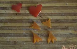 Вырезаем из моркови лапки лебедей и из кусочка перца сердечки.