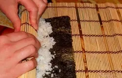 С помощью коврика сворачиваем нори в рулет.