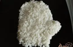 На блюдо в форме варежки выложить рис,смазать майонезом.