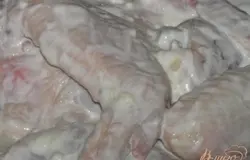 Смешать сметану и измельченный чеснок, обмазать куриные кусочки, оставить на 30 минут.