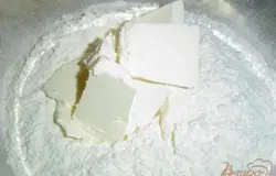 К просеянной муке добавляем сливочное масло, порезанное кусочками, хорошенько перетираем до образование крошки,