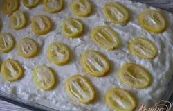 Выложить тесто в смазанную маслом форму для выпечки, кумкват разрезать напополам, выложить на тесто, слекга вдавить,