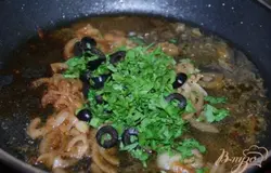 Выкладываем курицу на блюдо, а к соусу на сковороде добавляем маслины, зелень и сок лимона. Всё перемешиваем.
