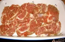 Мясо кладем на блюдо для запекания, сверху смазать сметаной или майонезом.